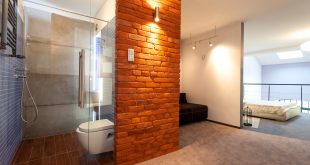 Modernes Bad mit beleuchteter Steinmauer